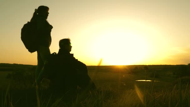 Free travelers rest on a hilltop and enjoy sunset. silhouette of traveler, sitting on hilltop, drinking coffee in thermos. tourist is drinking hot tea and watching sunset. Freedom and dream concept. — Stock Video
