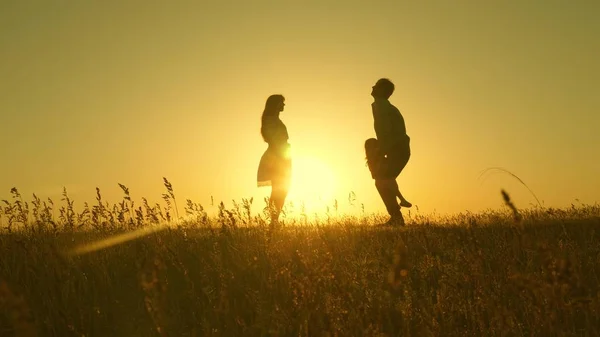 Barn, pappa och mamma leker på ängen i solen. begreppet lycklig barndom. Mor, far och dotter går på en äng i solen. Lycklig ung familj. begreppet lycklig familj. — Stockfoto