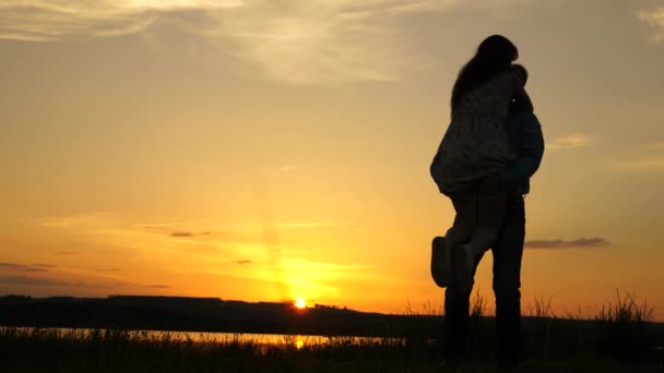 Young couple dancing at sunset on beach. Happy guy and girl waltz in evening in the summer park. Loving man and woman dance in bright rays of sun on the background of the lake. — Stock Video