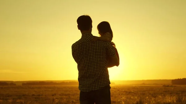 Papa enfant bien-aimé dans ses bras danse en fuite et rit. Happy baby joue avec son père au coucher du soleil. Silhouette d'un homme et d'un enfant. Concept de famille — Photo