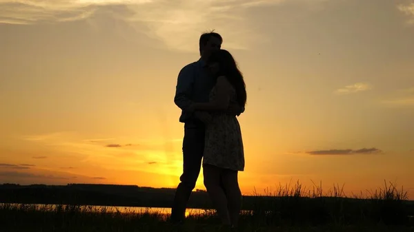 Casal jovem dançando ao pôr do sol na praia. Rapaz feliz e menina valsa à noite no parque de verão. Homem amoroso e mulher dançam em raios brilhantes de sol no fundo do lago . — Fotografia de Stock