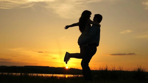 Jeune couple dansant au coucher du soleil sur la plage. Joyeux garçon et fille valse en soirée dans le parc d'été. Aimant homme et femme dansent dans les rayons lumineux du soleil sur le fond du lac . — Photo