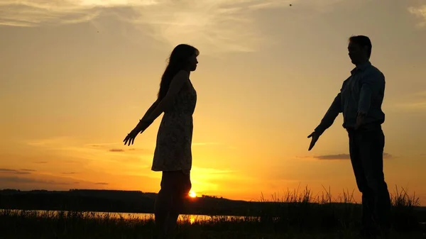 Jeune couple dansant au coucher du soleil sur la plage. Joyeux garçon et fille valse en soirée dans le parc d'été. Aimant homme et femme dansent dans les rayons lumineux du soleil sur le fond du lac . — Photo