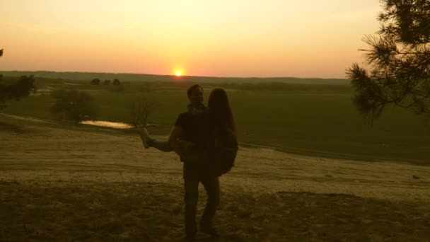 Happy Travelers. A man and a woman dance and rejoice and enjoy sunset. Teamwork travelers with backpacks. Family of tourists on vacation. Travels enjoy scenery at sunset. Hiker Girl. Slow motion. — ストック動画