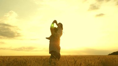 The child and parent play in nature. happy family and childhood concept. Slow motion. little daughter on fathers shoulders. baby boy and dad travel on a wheat field.