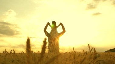 The child and parent play in nature. happy family and childhood concept. Slow motion. little daughter on fathers shoulders. baby boy and dad travel on a wheat field.
