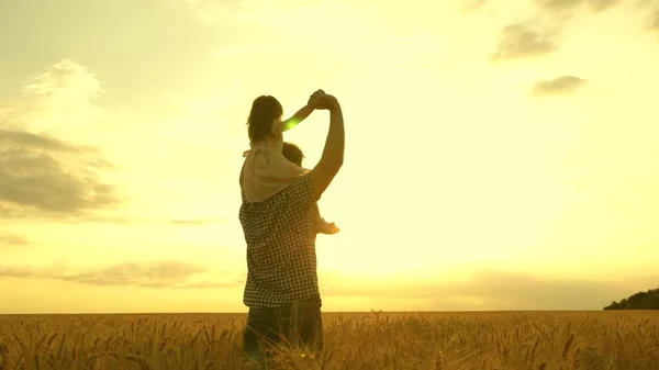 Дитина і батько грають на природі. щаслива концепція сім'ї та дитинства. Повільний рух. маленька донька на плечах батьків. хлопчик і тато подорожують на пшеничному полі . — стокове фото