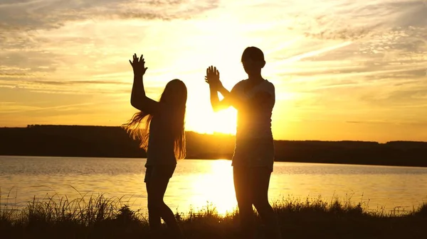 Party by the lake, the girls are dancing. teens girlfriends holiday disco. happy girls dancing on the beach. beautiful girls having fun listening to music. sisters are dancing. — Stock Photo, Image