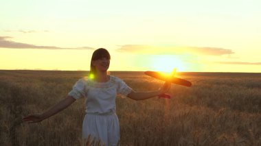 Mutlu kız bir çiçek alanında bir oyuncak uçak ile çalışır. çocuklar oyuncak uçak oynarlar. uçan ve bir pilot olma genç hayalleri. kız bir pilot ve astronot olmak istiyor.