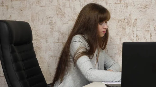 Hermosa mujer de negocios está trabajando con documentos en la oficina. mujer de negocios libre en su lugar de trabajo. Una joven que trabaja en la oficina de la computadora. empleado cansado . — Foto de Stock