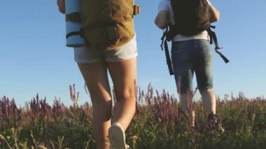Ekolojik turizm. Turistler sırt çantalarıyla çayırlarda dolaşırlar. Gezginler el ele gider. Turistlerin takım çalışması. Kırsalda çocuklu bir turist ailesi. Zafere giden yol.