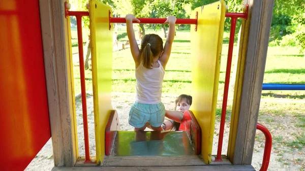 Madre y el bebé juegan en el patio de recreo. niño se ríe y disfruta del parque infantil. niño juega con mamá en la calle . — Foto de Stock