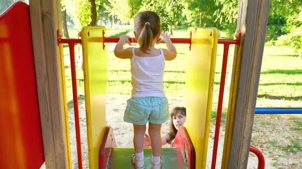 Madre y el bebé juegan en el patio de recreo. niño se ríe y disfruta del parque infantil. niño juega con mamá en la calle . — Foto de Stock