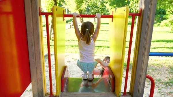 Madre y el bebé juegan en el patio de recreo. niño se ríe y disfruta del parque infantil. niño juega con mamá en la calle . — Foto de Stock