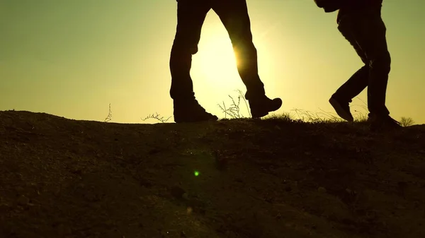チームワークの大切さです。無料の旅行者の足冒険者は美しい太陽の光の中で山の頂上に沿って歩く。観光客は日没時に山の中を旅する。勝利と成功のために. — ストック写真