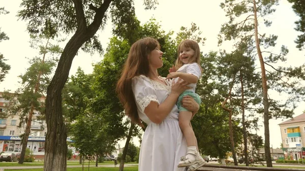 Счастливая детская концепция. счастливая мама обнимает маленькую дочь в парке на открытом воздухе. Красивая мать и ее ребенок играют в парке. ребенок и обнимает счастливую мать. Счастливого Дня Матери. Мама и ребенок. 4K — стоковое фото