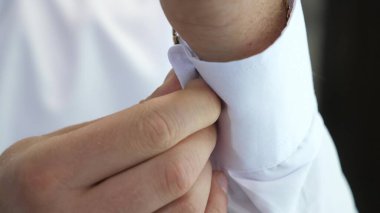 young businessman going to a business meeting. Mens hands fasten a button on the sleeve of a white shirt. a man puts on clothes in the morning to work. office worker. Man dressing close-up.