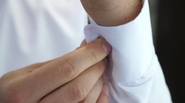 young businessman going to a business meeting. Mens hands fasten a button on the sleeve of a white shirt. a man puts on clothes in the morning to work. office worker. Man dressing close-up.