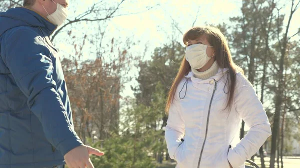 保護マスクの少女と保護マスクの男が路上で会う。流行性コロナウイルス。ストリートの観光客はウイルスから保護マスクを着用する。概念的な健康と安全性N1h1コロナウイルス — ストック写真