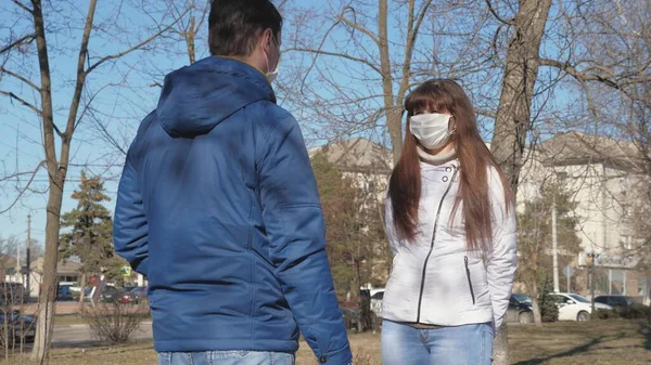 coronavirus. young girl in a protective mask and man in protective mask meet on street. Pandemic Coronavirus. tourists on street wear protective mask from viruses. concept health and safety, N1H1