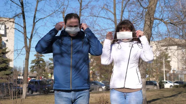 Το νεαρό κορίτσι και ο άντρας φορούν προστατευτική μάσκα στο δρόμο. τουρίστες στο δρόμο φορούν προστατευτική μάσκα από ιούς. Πανδημία του Coronavirus. έννοια της υγείας και της ασφάλειας, N1h1 coronavirus, προστασία του ιού — Φωτογραφία Αρχείου