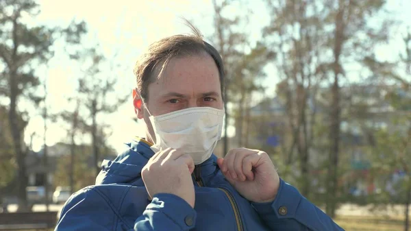 Пандемия гриппа. человек надевает медицинскую защитную маску на улице в городе. Покажи. Крупный план. концепция безопасности и здоровья, коронавирус N1H1, защита от вирусов. концепция безопасности и здоровья . — стоковое фото