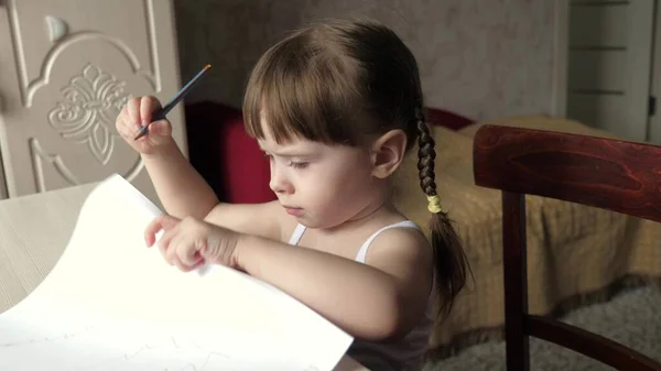 Criança desenha na folha de papel branco. Bonito pequeno artista menina criança lápis de cera em um quarto em uma mesa. criança pré-escolar inteligente focada desfrutando de hobby de arte criativa em atividade doméstica. conceito de desenvolvimento infantil — Fotografia de Stock