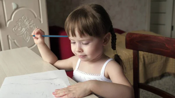 Criança desenha na folha de papel branco. Bonito pequeno artista menina criança lápis de cera em um quarto em uma mesa. criança pré-escolar inteligente focada desfrutando de hobby de arte criativa em atividade doméstica. conceito de desenvolvimento infantil — Fotografia de Stock