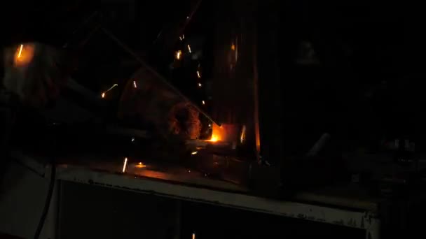 Luz brillante y chispas de soldadura. Trabajador industrial en una máscara protectora utilizando una moderna máquina de soldadura para soldar estructuras metálicas en producción industrial en una planta de procesamiento de metales . — Vídeos de Stock