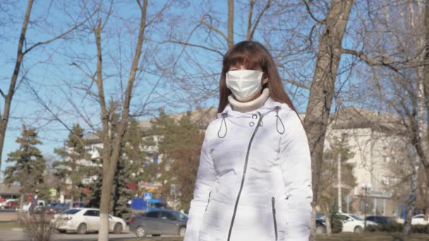 Una chica con una máscara protectora de virus y bacterias está parada en la calle. Coronavirus pandémico. concepto salud y seguridad, coronavirus N1H1, protección del virus. protección contra virus y bacterias . — Vídeo de stock