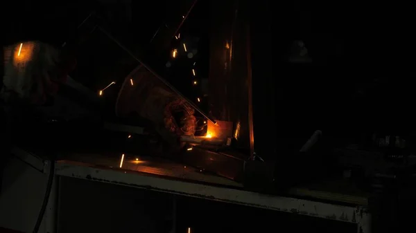 Bright light and sparks from welding. Industrial worker in a protective mask using a modern welding machine for welding metal structures in industrial production at a metal processing plant. — Stock Photo, Image