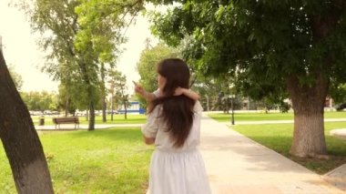 Bebek ve mutlu annesine sarılıyor. Güzel anne açık havada parkta küçük bir kızı taşıyor. Güzel anne ve bebeği parkta oynuyorlar. Anneler Günün kutlu olsun. Anne ve bebek. 4K