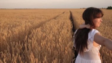 Benimle el ele gelin. Çocuk yaz tarlasında yürürken mutlu ve genç bir aile. Sağlıklı anne, baba ve küçük kız birlikte doğanın tadını çıkarıyorlar. Ağır çekim. 4K UHD video.