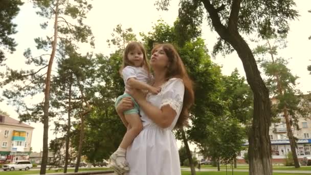 Krásná matka a její dítě si hrají v parku. dítě a objímá šťastnou matku. Šťastná radost ze Dne matek. Máma a dítě 4K. Šťastné dětství. šťastná maminka objetí malá dcera v parku venku. — Stock video