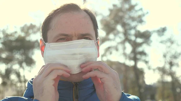Пандемія грипу. чоловік одягає медичну захисну маску на вулицю в місті. крупним планом. Концепція безпеки та здоров'я, коронавірус N1H1, захист від вірусів. концепція безпеки та здоров'я . — стокове фото