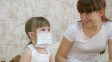 Küçük kız karantina altında, oyuncak ayıya tıbbi maske takıyor. Caronovirüs ve gribe karşı koruma. Bebek hastanede oynuyor. Çocuk doktorla, hemşireyle, veterinerle, hastayla oynuyor..