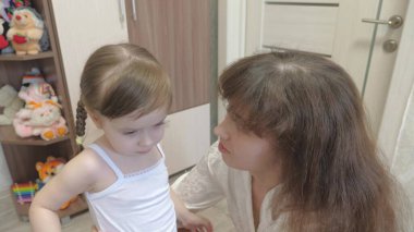 Sevgi dolu bir kız, sevimli bir anneye sarılır. Küçük bebek annesine sarılıyor. Mutlu aile oynuyor. Bebek annesine sıkıca sarılır ve onu öper. annelik ve kahkaha günü konsepti
