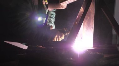Parlak ışık ve kaynaktan çıkan kıvılcımlar. Metal işleme tesisinde endüstriyel üretim yapan metal yapıları kaynak yapmak için modern kaynak makinesi kullanan koruyucu bir maske takan endüstriyel işçiler..