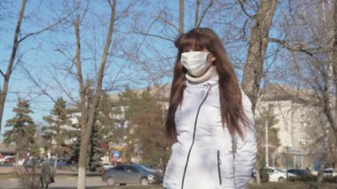 Koronavirüs. Koruyucu maskeli genç bir kız ve koruyucu maskeli bir adam sokakta buluşuyor. Salgın Koronavirüs. Sokaktaki turistler virüslerden korunmak için koruyucu maske takarlar. konsept sağlık ve güvenlik, N1H1