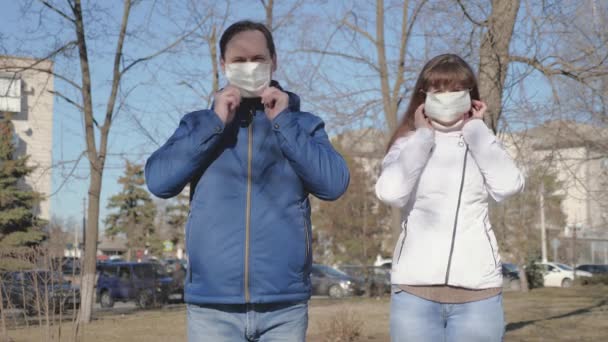 Genç kız ve erkek sokakta koruyucu maske takıyor. Sokaktaki turistler virüslerden korunmak için koruyucu maske takarlar. Salgın Koronavirüs. konsept sağlık ve güvenlik, N1h1 koronavirüs, virüs koruması — Stok video