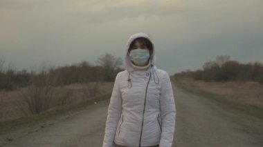 Korunaklı tıbbi maske takan Kordemik Koronavirüs kadın turisti şehir dışında yolda yürüyor. Virüs ve bakterilere karşı koruma. Sağlık ve güvenlik konsepti, koronavirüs N1H1, koruma