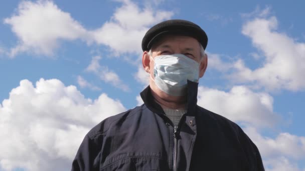 Літня людина на вулиці в медичній масці. Пандемічний коронавірус. людина носить захисну маску на вулиці. концепція здоров'я, карантин коронавірусу N1H1, захист від вірусів. ризик зараження . — стокове відео