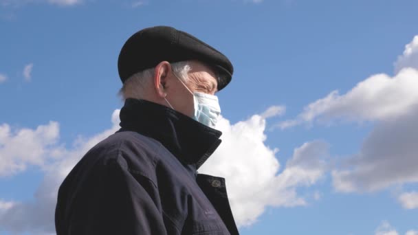 Risk of infection. An elderly man in the street in a medical mask. Pandemic coronavirus. man wears a protective mask on street. health concept, quarantine of coronavirus N1H1, virus protection. — Stock Video