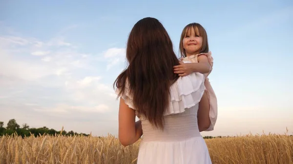 Šťastná rodina cestuje. dítě v náručí mámy. šťastný rodinný koncept. Máma a dcerka si hrají na poli zralý pšenice na slunci. matka chodí s dítětem na poli s pšenicí. — Stock fotografie