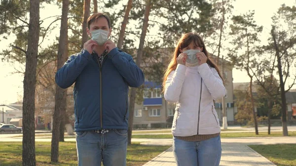 若い女の子と男が通りに保護マスクを着用し、のように示しています。人々はウイルスの医療用マスクを着用し授業を見せる。流行性コロナウイルスの健康と安全の概念,コロナウイルスN1H1,ウイルス保護 — ストック写真