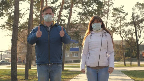 Jeune fille et homme portent un masque de protection dans la rue, montrant comme. Les gens portent un masque médical pour les virus, montrent la classe. Concept de santé et de sécurité contre le coronavirus pandémique, coronavirus N1H1, protection contre le virus — Photo