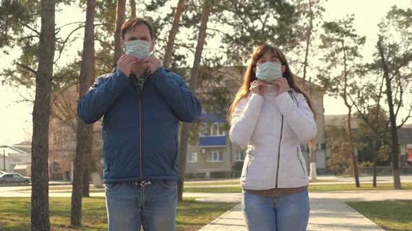 Ung flicka och man bär en skyddande mask på gatan, visar som. Människor bär medicinsk mask för virus, visa klass. Pandemic Coronavirus - hälso- och säkerhetskoncept, coronavirus N1H1, virusskydd — Stockfoto