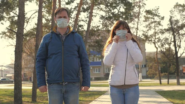 若い女の子と男が通りに保護マスクを着用し、のように示しています。人々はウイルスの医療用マスクを着用し授業を見せる。流行性コロナウイルスの健康と安全の概念,コロナウイルスN1H1,ウイルス保護 — ストック写真