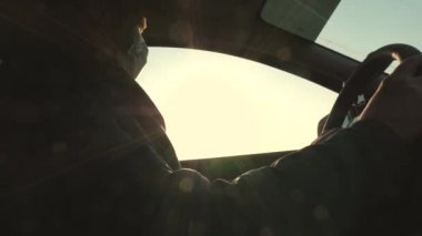 Salgın koronavirüsü koruma kavramı. Koruyucu steril tıbbi maskeli özgür sağlıklı kadın araba kullanıyor. Kız arabayla maskeyle seyahat ediyor. Virüs ve bakterilere karşı koruma. Kız arabaya biniyor.