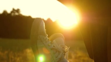 Bedava sağlıklı kız arabayla seyahat etmeyi sever, bacaklarını açık pencereden dışarı çıkarır. Araba camında bir kızın bacakları, güneş ışığı, kır yolunda bir arabaya binmek..